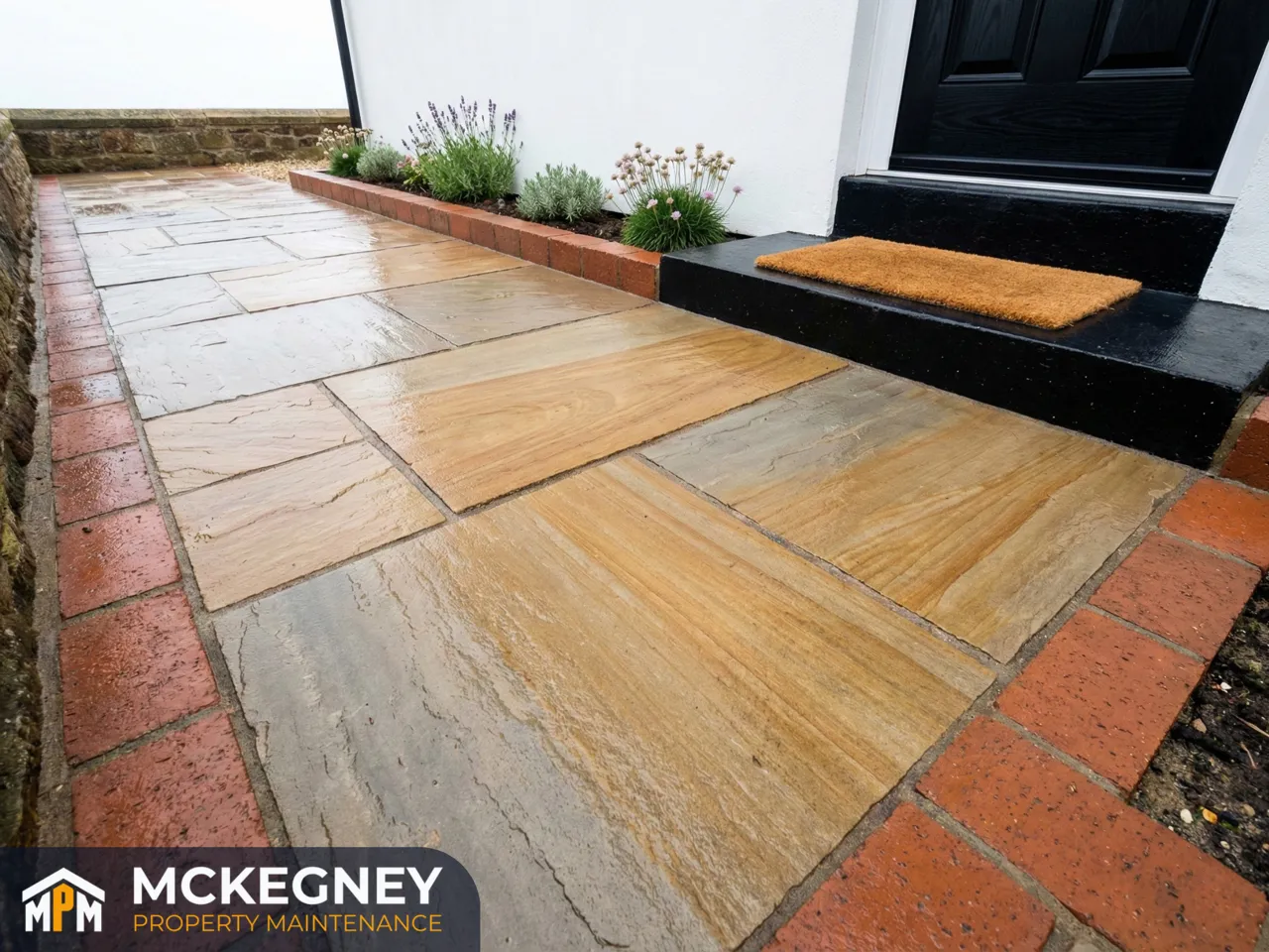 Restored sandstone path with crisp brick edging and clean surface texture outside a coastal home — McKegney Property Maintenance.